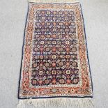 A Persian woollen rug, with floral design, on a blue ground,