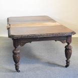 A Victorian carved oak wind out extending dining table, with two additional leaves,