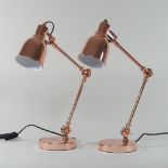 A pair of copper coloured anglepoise table lamps