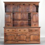 An 18th century style oak dresser, with a plate rack above, and cupboards below,