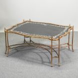 A gilt and black painted coffee table, decorated with flowers,