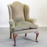 A Georgian style green suede upholstered wing back armchair,