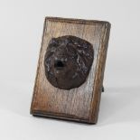 A cast iron lion mask fountain, mounted on a wooden easel,