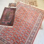 A bokhara style woollen rug, on a red ground, 300 x 200cm,