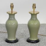 A pair of green glazed and brass mounted pottery table lamp bases,