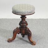 A Victorian carved walnut adjustable piano stool,