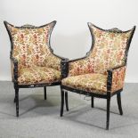 A pair of carved ebonised and floral upholstered shaped armchairs,