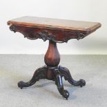A Victorian rosewood card table, on a quadruped base,