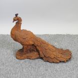 A rusted metal figure of a peacock,