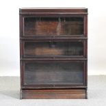 An early 20th century oak glazed three tier sectional bookcase,