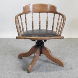 An early 20th century elm spindle back revolving desk chair,