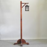 An Arts and Crafts oak hanging lantern on stand,