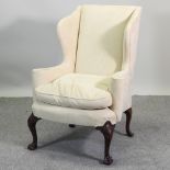 A 19th century style cream upholstered wing armchair