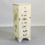 A cream painted jewellery cabinet, decorated with flowers and birds,