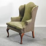 A Georgian style green suede upholstered wing back armchair,