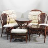 A wicker conservatory suite comprising of two armchairs, two side chairs, a circular table,