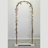 A decorative brass arch, relief decorated with flowers, foliage and lights,