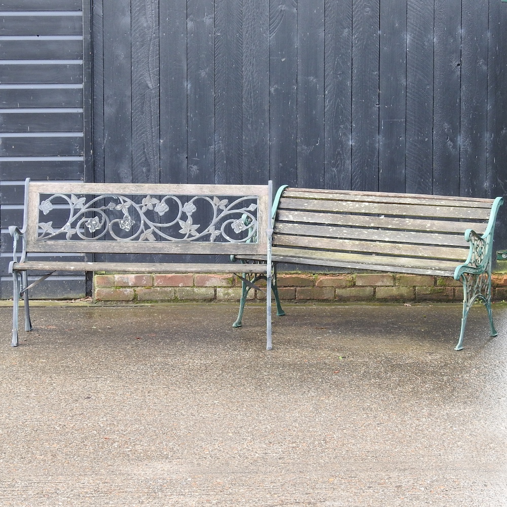 A wooden garden bench, with painted metal ends, together with another,