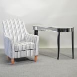A modern grey striped upholstered armchair, together with a mirrored console table,