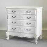 A French style white painted serpentine chest, containing four long drawers, on cabriole legs,