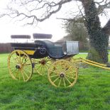 A black and yellow painted horse carriage,