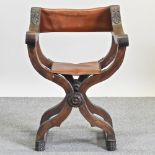 An early 20th century oak folding x-frame armchair,