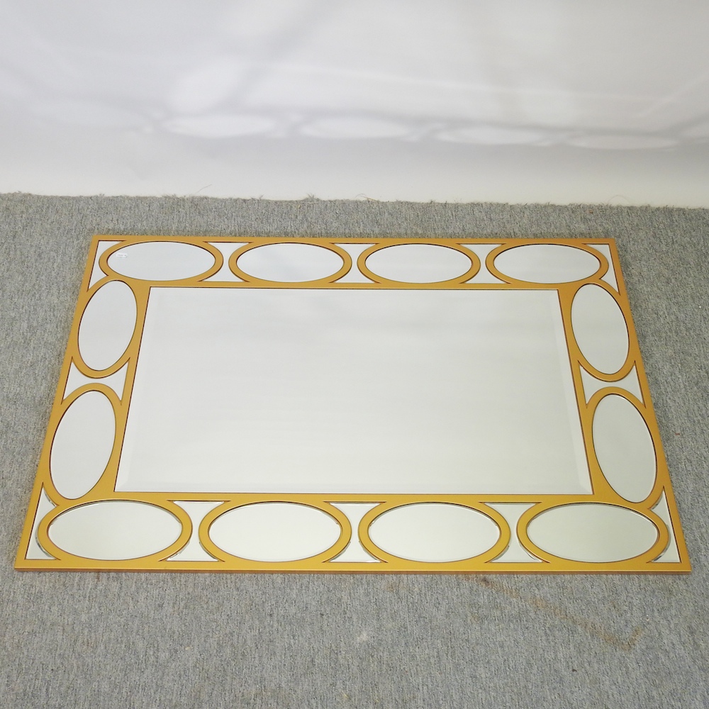 A modern gold coloured metal sectional wall mirror,