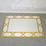 A modern gold coloured metal sectional wall mirror,