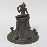 An unusual bronze inkwell, decorated with goblin on a tree stump,