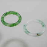 A jade coloured hardstone bangle, together with another,