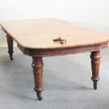A Victorian mahogany wind out extending dining table, with two additional leaves, on turned legs,