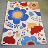 A contemporary woollen rug, with floral design, on a cream ground,