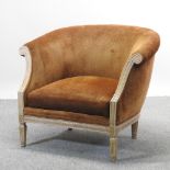 A carved and brown upholstered tub chair, of large proportions, on tapered legs,