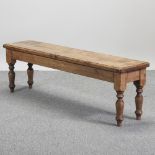 A bespoke made rustic pine bench, on turned legs,