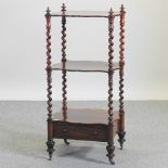 A late Regency rosewood three tier whatnot, of serpentine shape, united by spirally turned supports,
