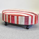 A modern oval shaped footstool, with striped upholstery,