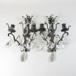 A pair of metal wall sconces, with glass drops,