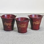 A set of three graduated painted metal Coca Cola advertising buckets,