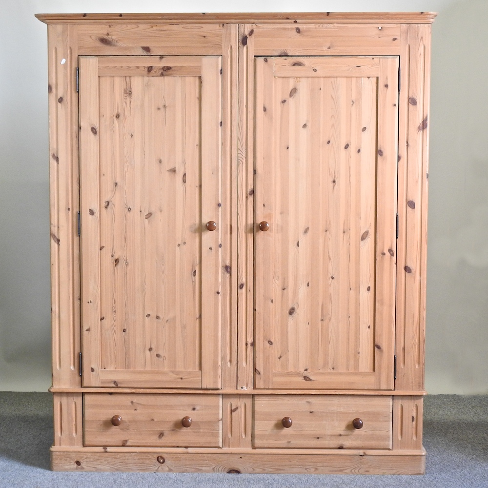 A modern pine double wardrobe, with drawers below,