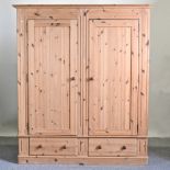 A modern pine double wardrobe, with drawers below,