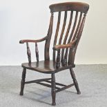 An early 20th century elm seated splat back armchair,
