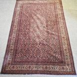 A Persian woollen tabriz style rug, on a red ground,