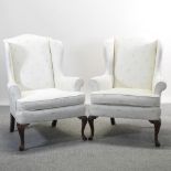 A pair of cream upholstered wing armchairs,