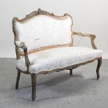 A carved gilt painted and cream upholstered show frame sofa,