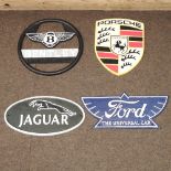 A reproduction Ford Universal sign, together with a Jaguar sign, a Bentley sign, and a Porsche sign,