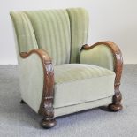 An Art Deco carved oak and green upholstered armchair,