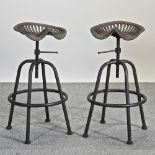 A pair of metal revolving tractor seat bar stools