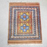 A Turkish woollen rug, with multiple boarders, on a red ground,
