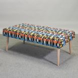 A 1950's style patterned upholstered footstool,