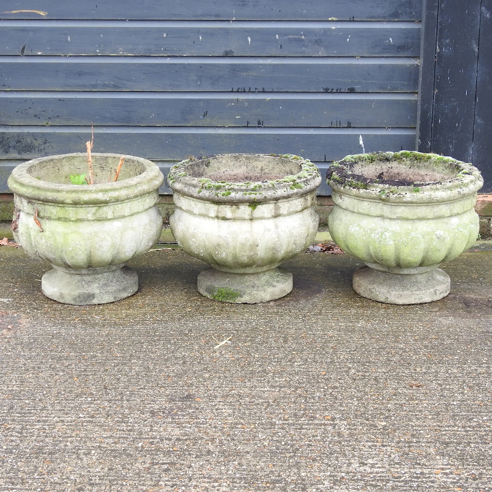 A set of three reconstituted stone garden planters,